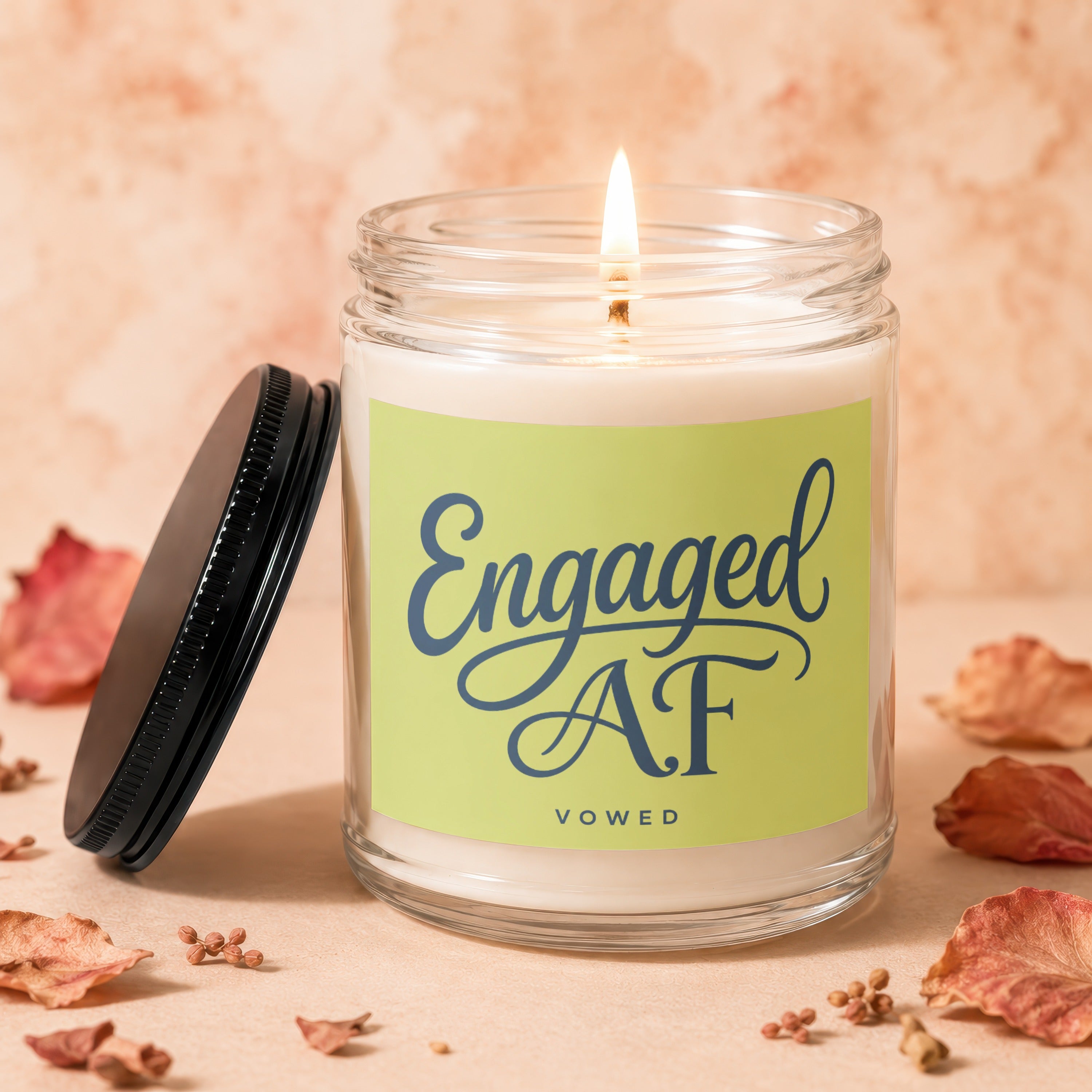 Lit candle in jar with "Engaged AF VOWED" on a light green label.