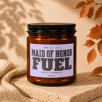 Brown glass candle with lavender label reading "Maid of Honor Fuel" and "Vowed".