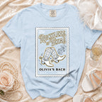 Light blue t-shirt with "Reckless in Texas" and cowboy boots graphic.