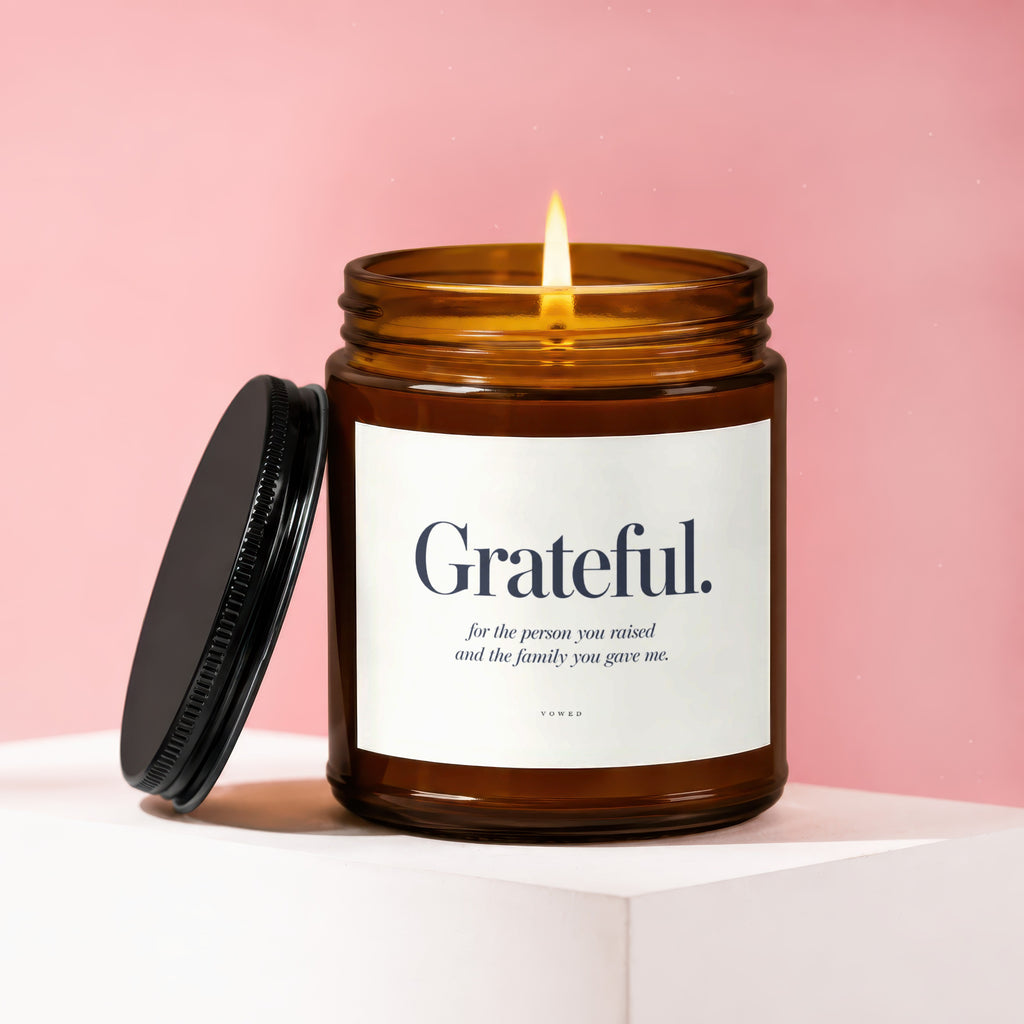 Amber jar candle with lit flame, labeled "Grateful." and accompanying text.