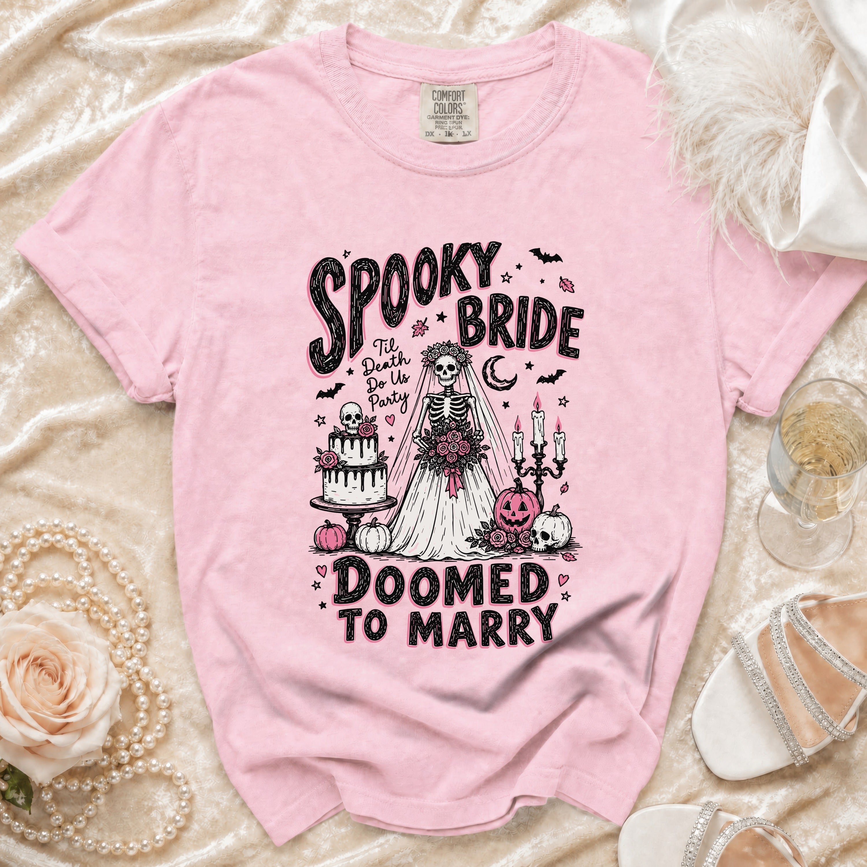 Pink t-shirt with "Spooky Bride Doomed to Marry" graphic featuring a skeleton bride.