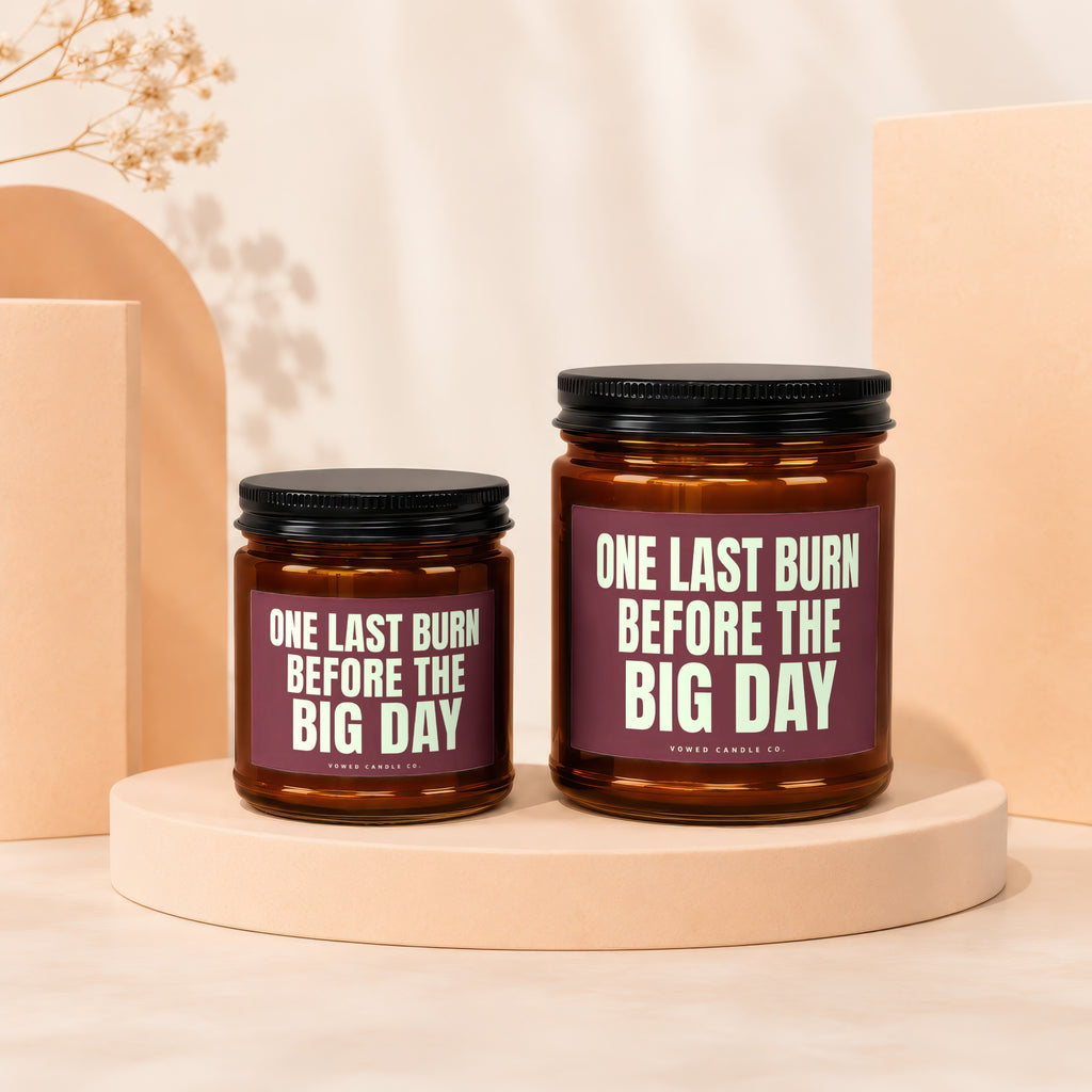 Two amber glass candles with black lids, labeled "One Last Burn Before the Big Day".