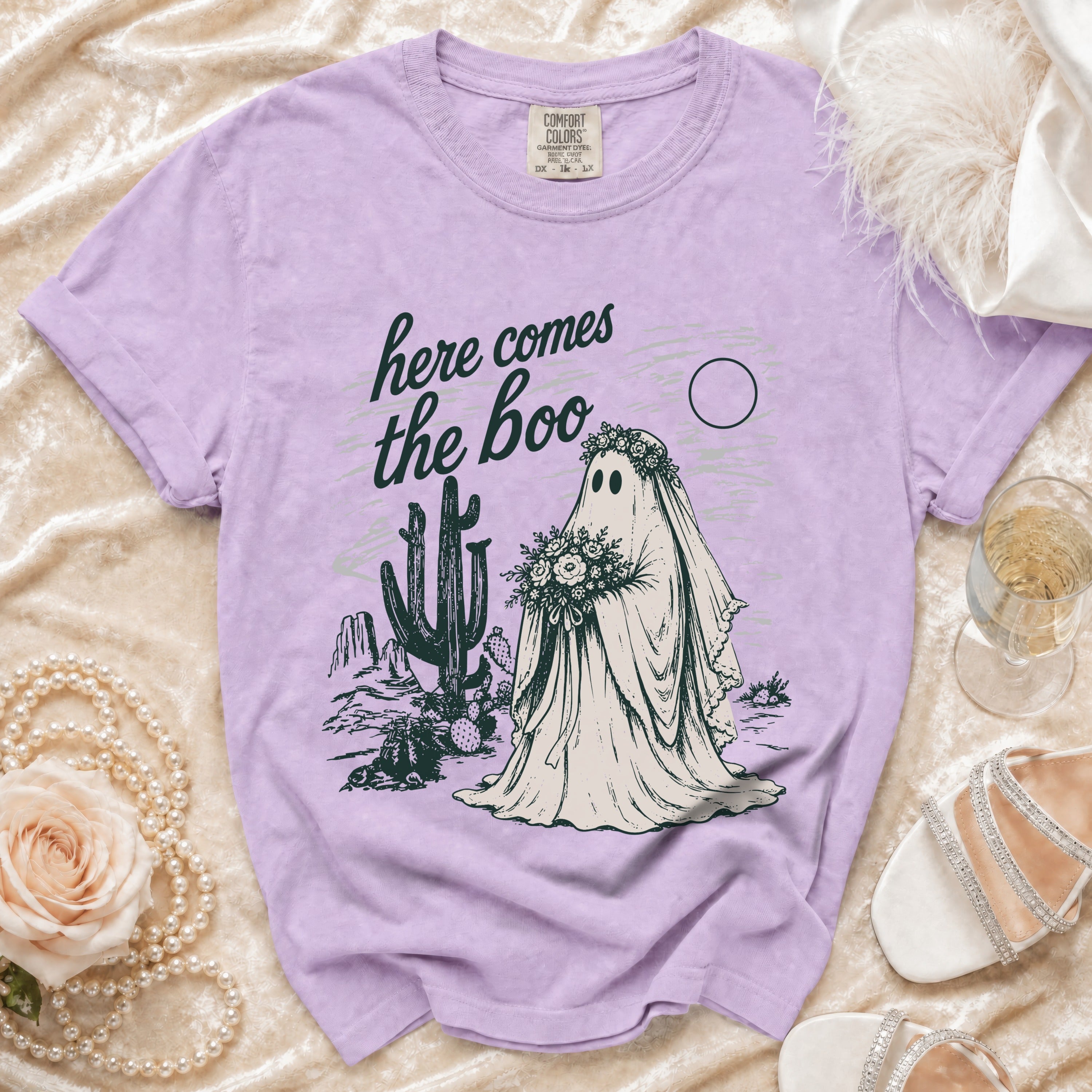 Purple t-shirt with ghost bride graphic saying "here comes the boo" in desert scene.