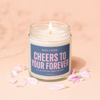 Candle with label "Cheers to Your Forever" surrounded by pink flower petals.