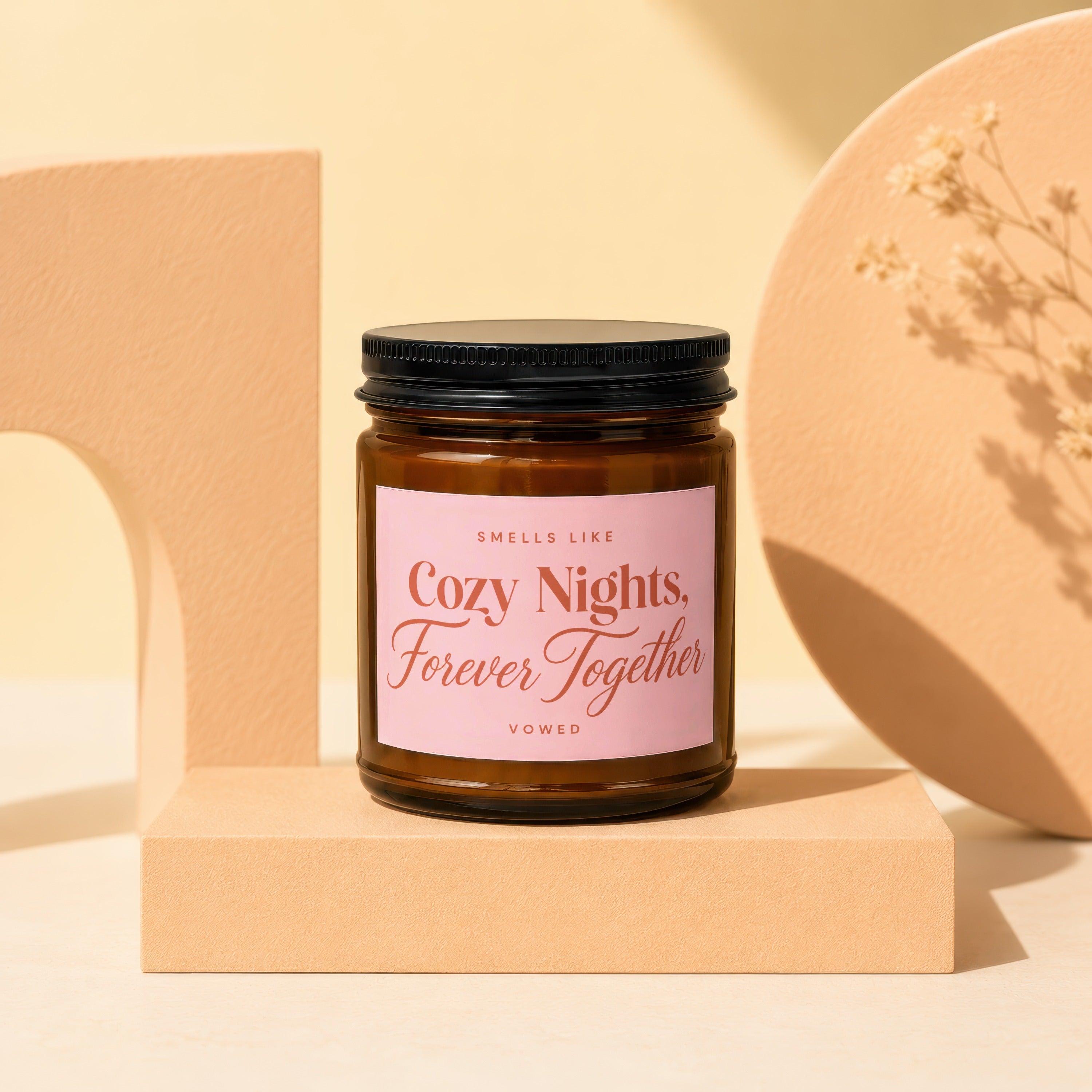 Amber glass candle with pink label that reads "Cozy Nights, Forever Together."