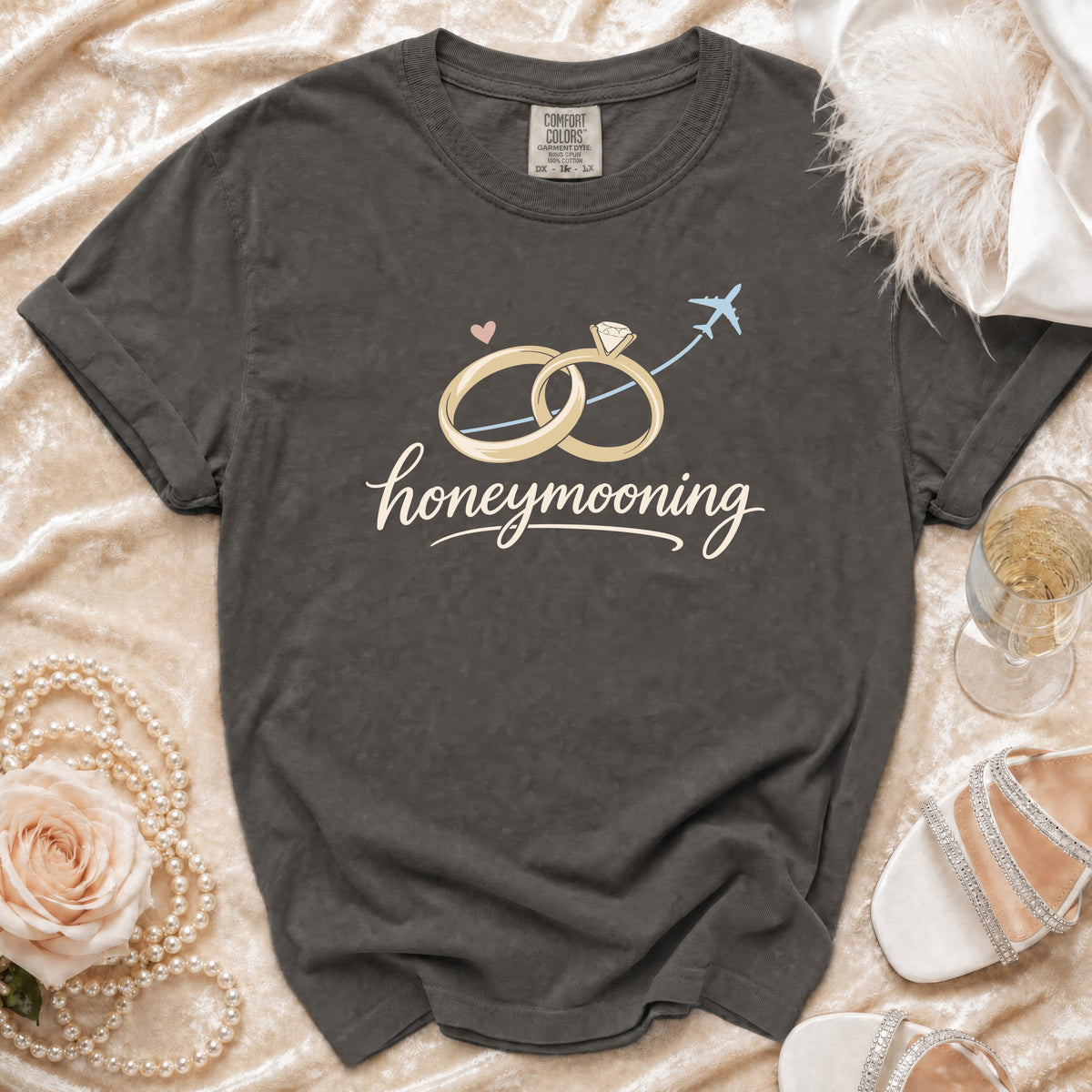 Dark grey t-shirt with "honeymooning" text and wedding rings graphic.