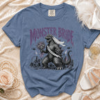 Blue t-shirt with "MONSTER BRIDE" and Godzilla wearing a veil and flowers.