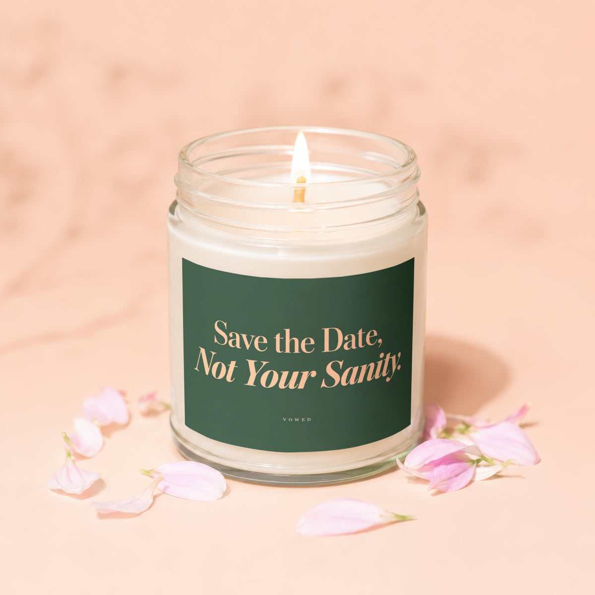 Candle with a lit wick and a dark green label that reads "Save the Date, Not Your Sanity."