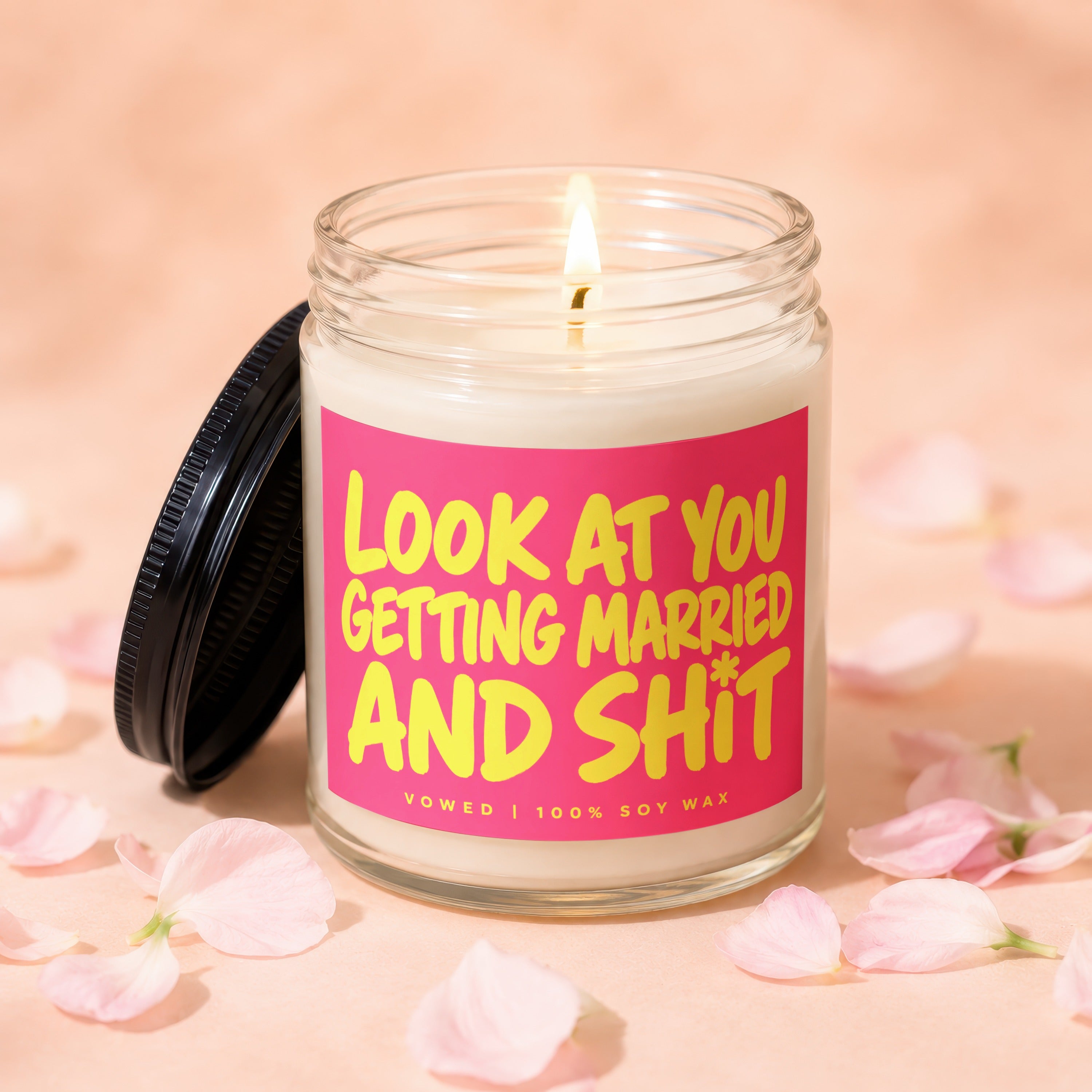 Candle with pink label reading "Look At You Getting Married and Shit"