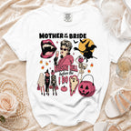 White t-shirt graphic "Mother of the Bride Raising Hell Before I Do" with Halloween imagery.
