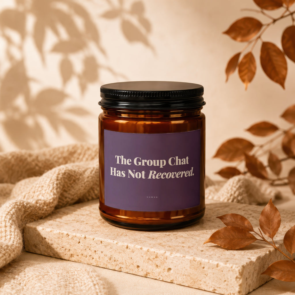 Amber jar candle with purple label reading "The Group Chat Has Not Recovered."