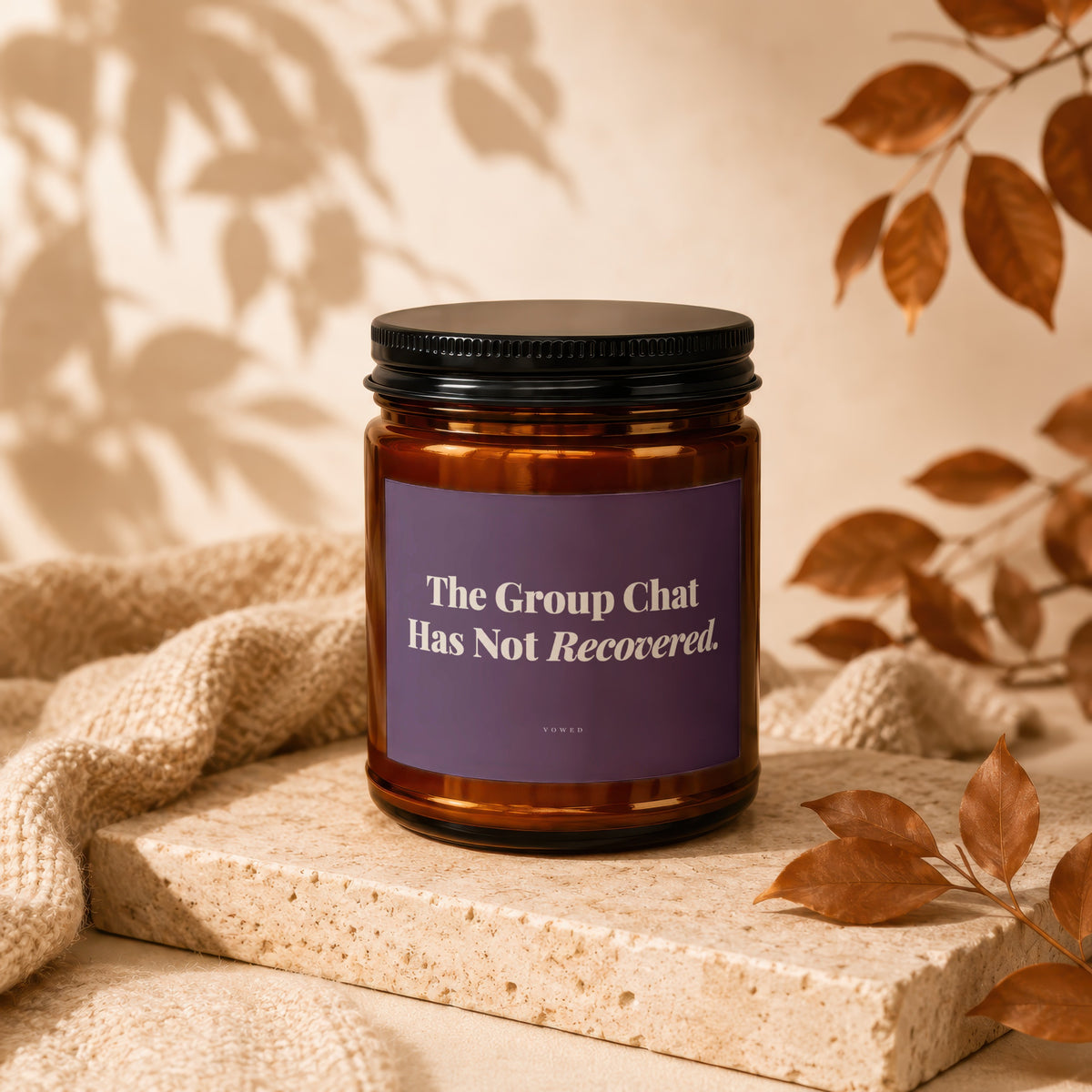 Amber jar candle with purple label reading "The Group Chat Has Not Recovered."