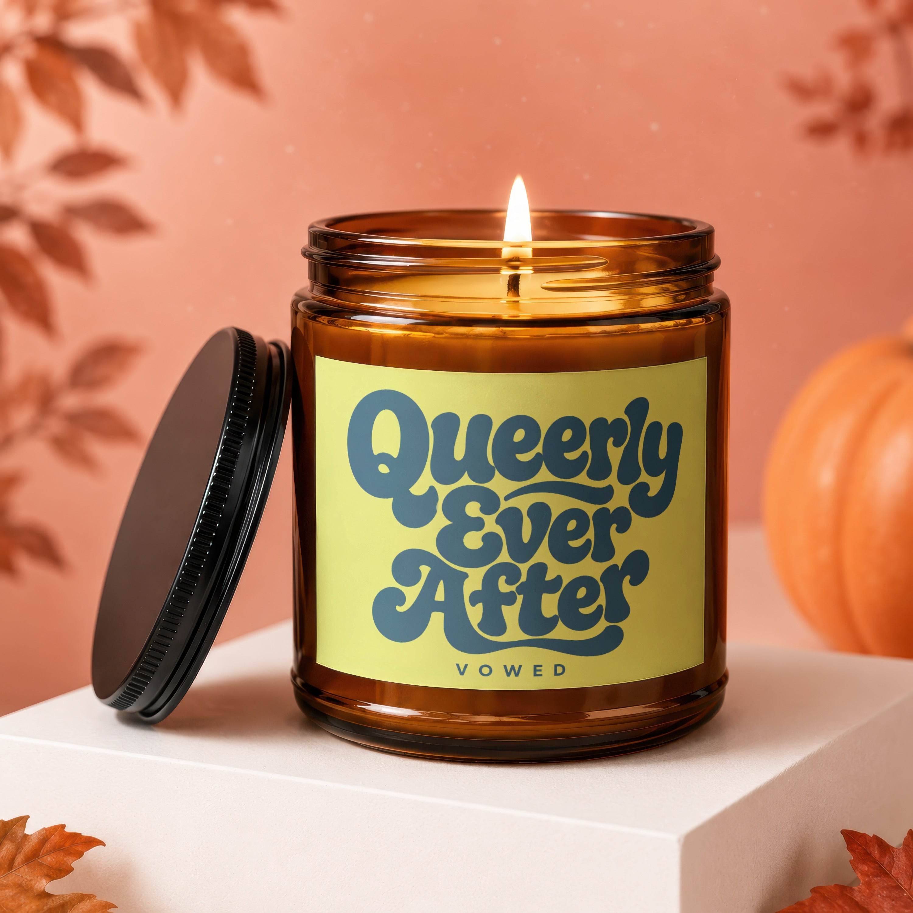 Amber jar candle with lid off, reads "Queerly Ever After VOWED".