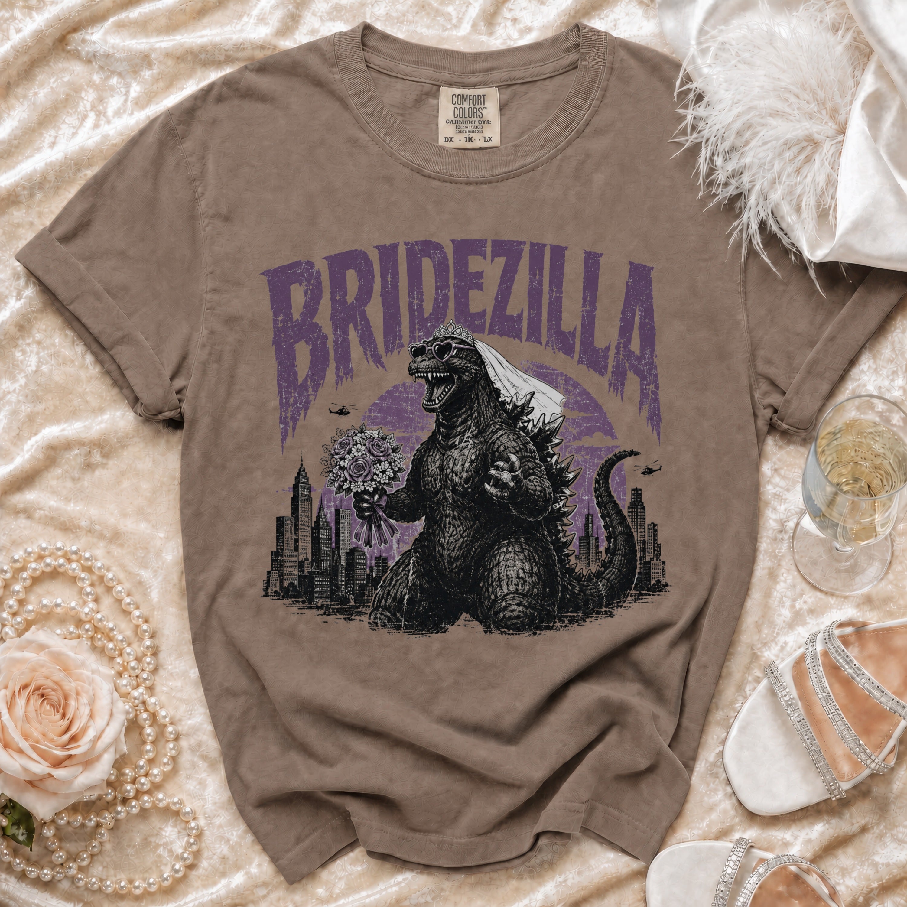 Godzilla wearing a veil and heart sunglasses holding a bouquet with "BRIDZELLA" text.