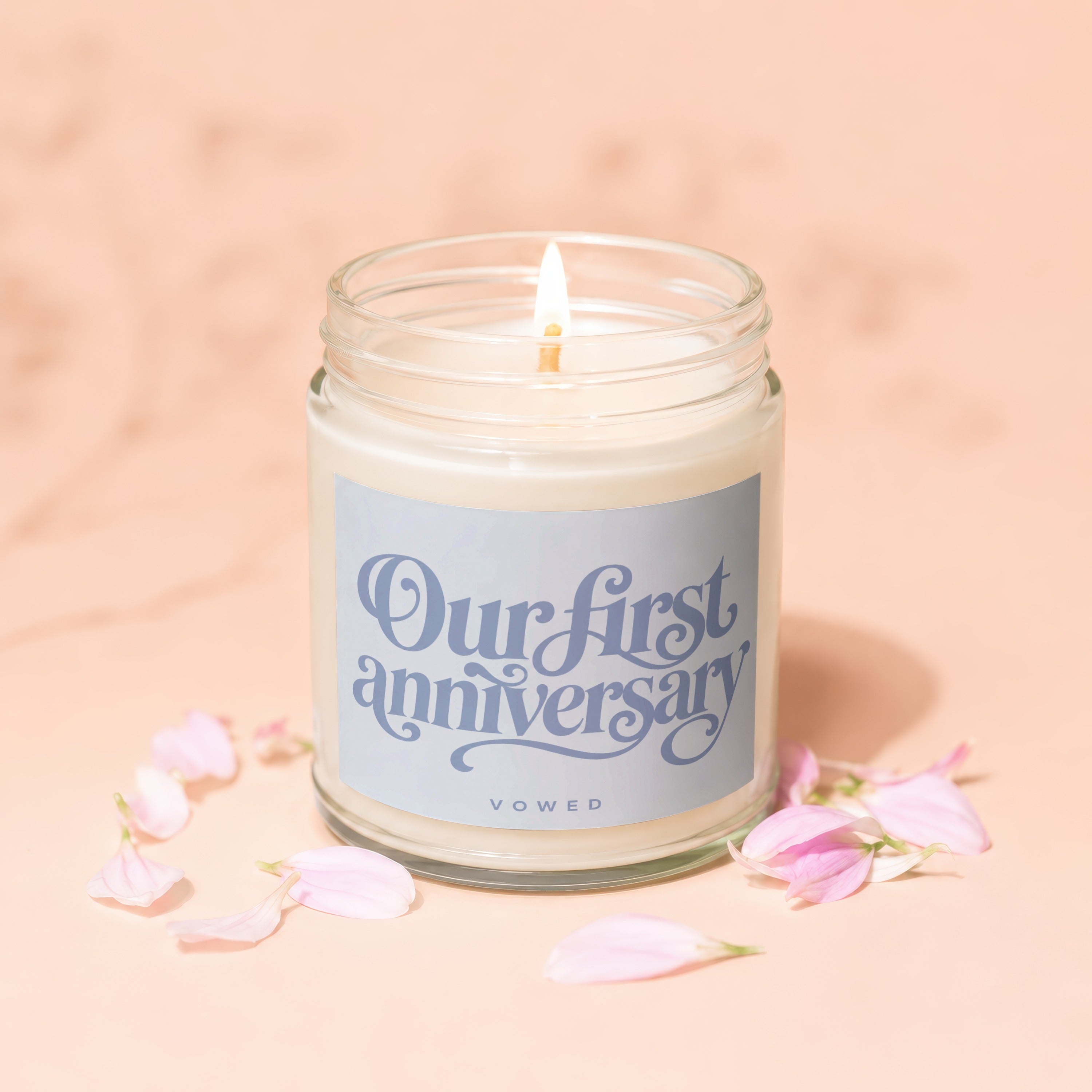 Candle with lit wick and label reading "Our first anniversary" and "vowed".