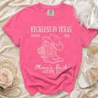 Pink t-shirt with "Reckless in Texas" cowboy boots and disco ball graphic.