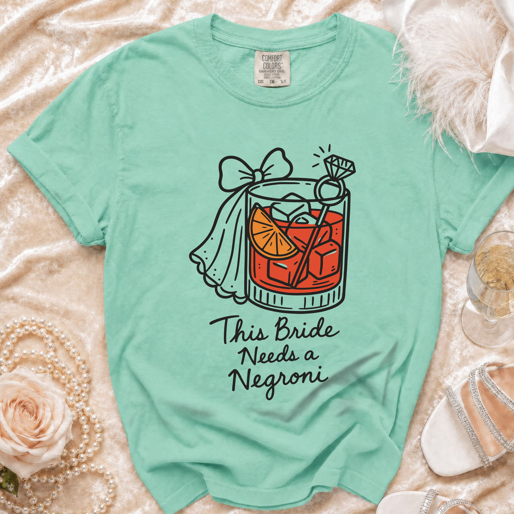 Mint green t-shirt with cocktail graphic and text "This Bride Needs a Negroni".