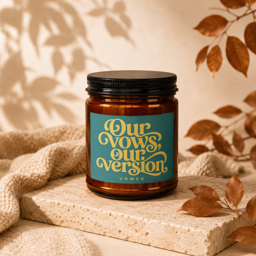 Amber candle with a teal label that reads "Our Vows, Our Version."