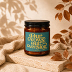 Amber candle with a teal label that reads "Our Vows, Our Version."