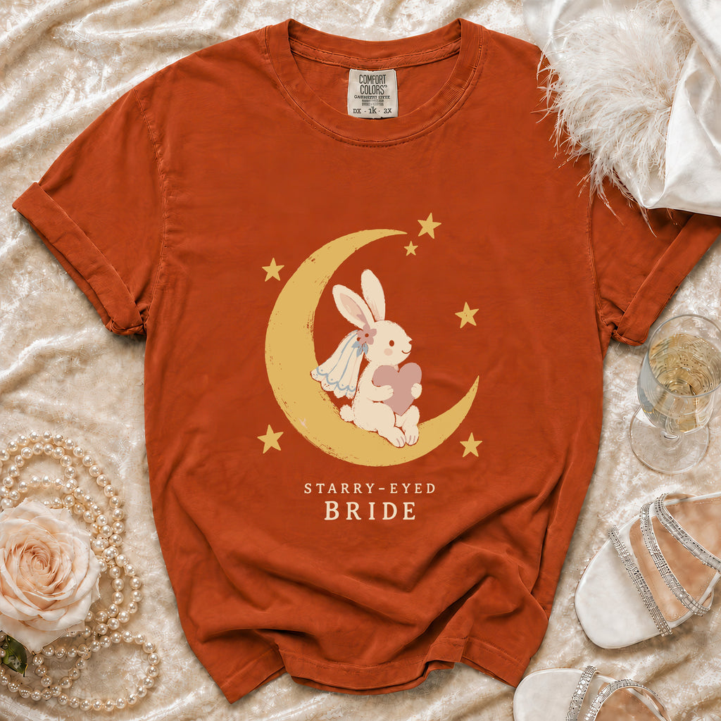 Orange t-shirt with a graphic of a bunny on a crescent moon and the text "STARRY-EYED BRIDE".