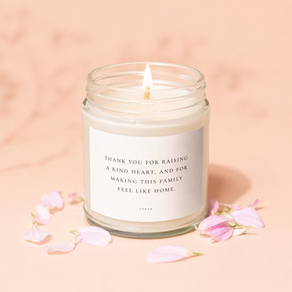 Candle with text "Thank you for raising a kind heart..." and pink petals.