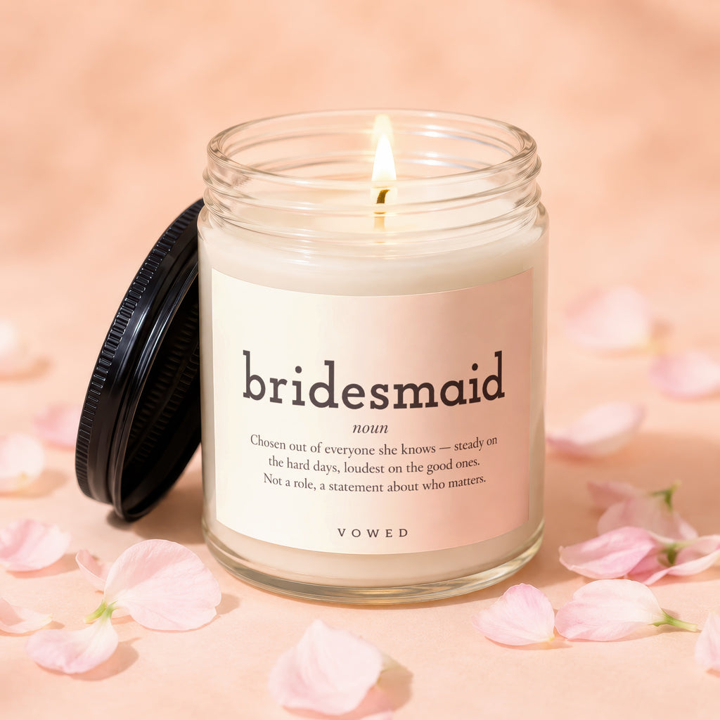 Glass candle with burning wick, reads "bridesmaid" and its definition.