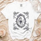 White t-shirt with a framed graphic of a ghost bride and floral accents.