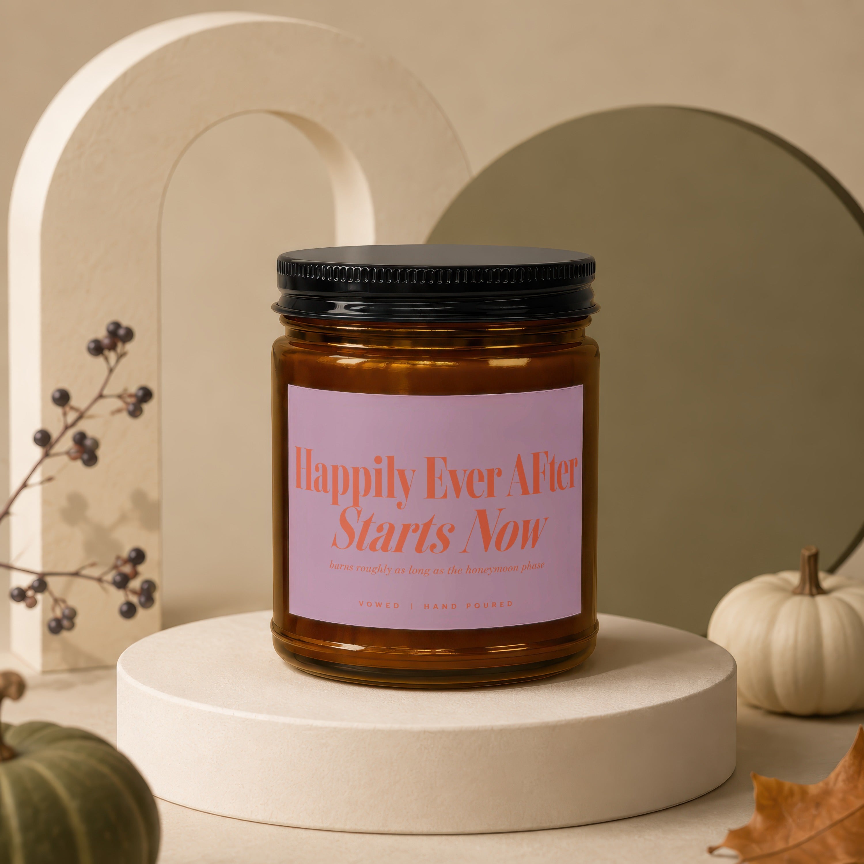 Amber jar candle with pink label reading "Happily Ever After Starts Now".
