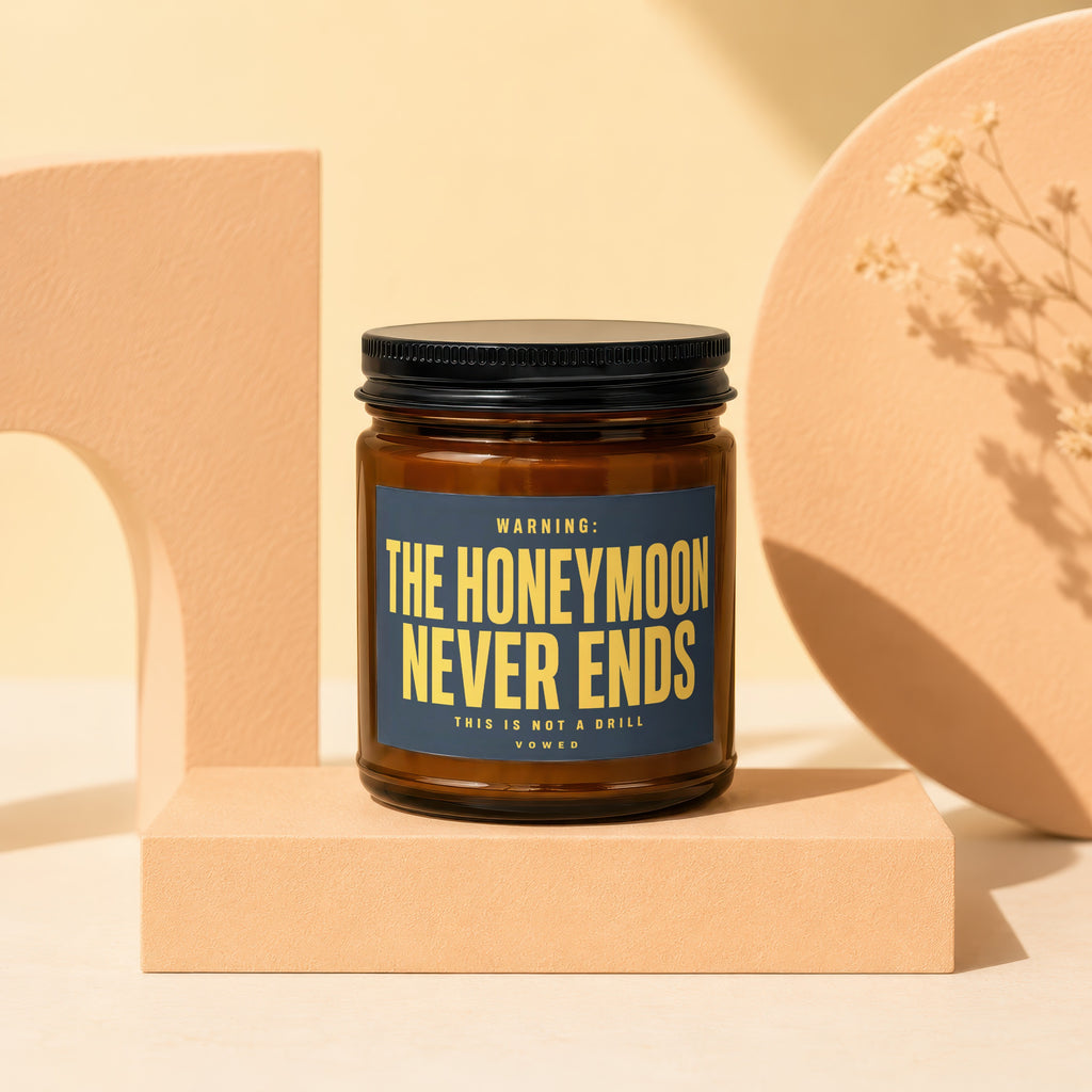 Amber candle with black lid and text "THE HONEYMOON NEVER ENDS".