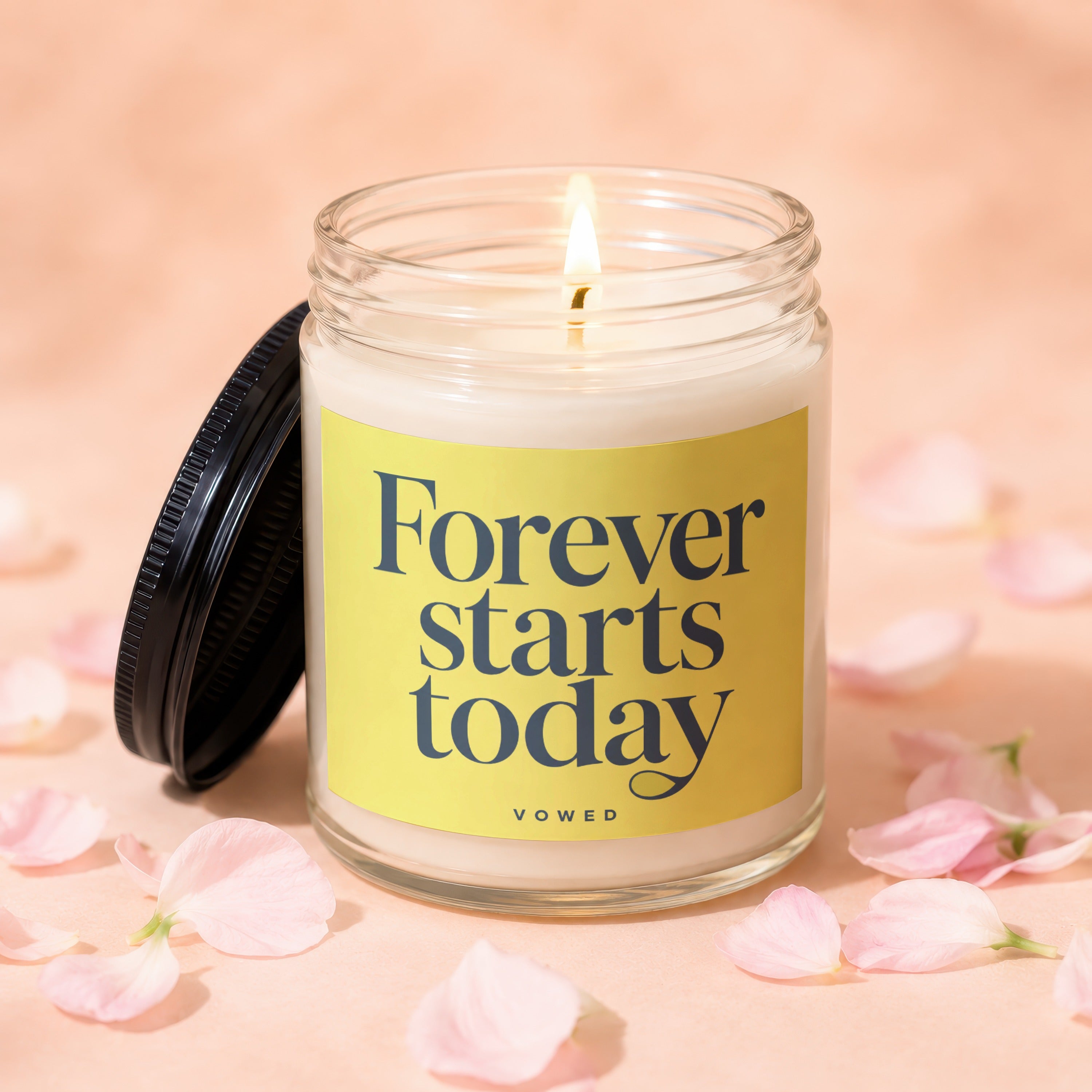 Lit candle in a glass jar with lid off, reads "Forever starts today"