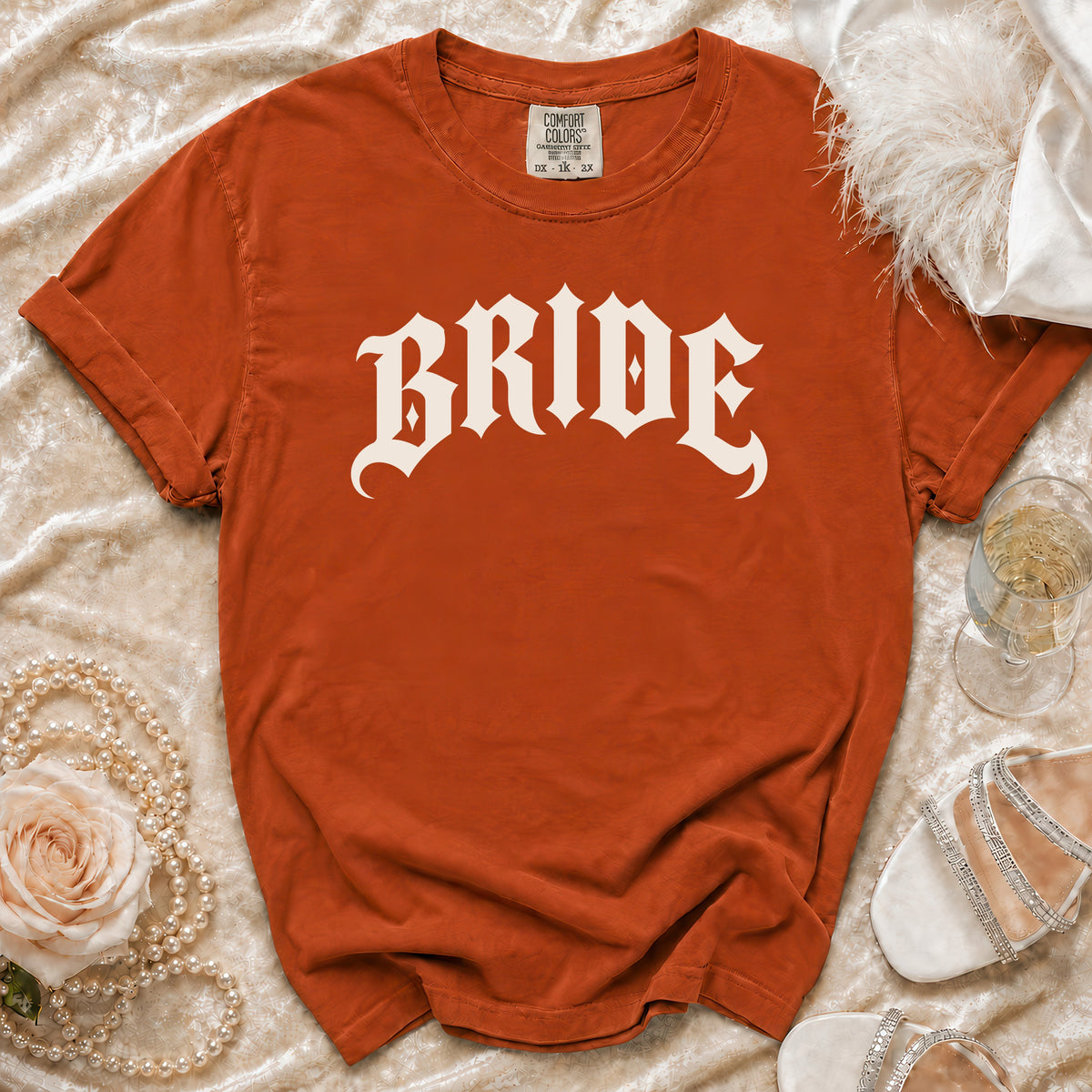 Orange t-shirt with white "BRIDE" text, shown with accessories.
