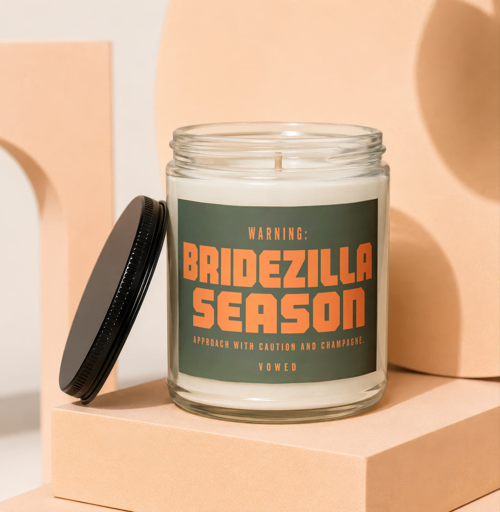 Glass candle with dark label warning "Bridezilla Season" and text "Vowed".