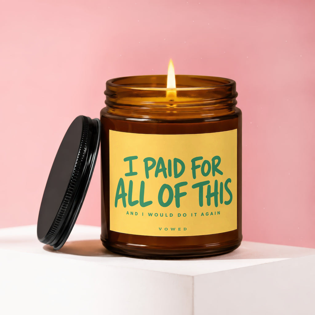Amber jar candle with lit wick and black lid, stating "I PAID FOR ALL OF THIS AND I WOULD DO IT AGAIN".