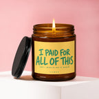 Amber jar candle with lit wick and black lid, stating "I PAID FOR ALL OF THIS AND I WOULD DO IT AGAIN".