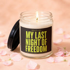 Glass candle with lit wick and "My Last Night of Freedom" text on label.