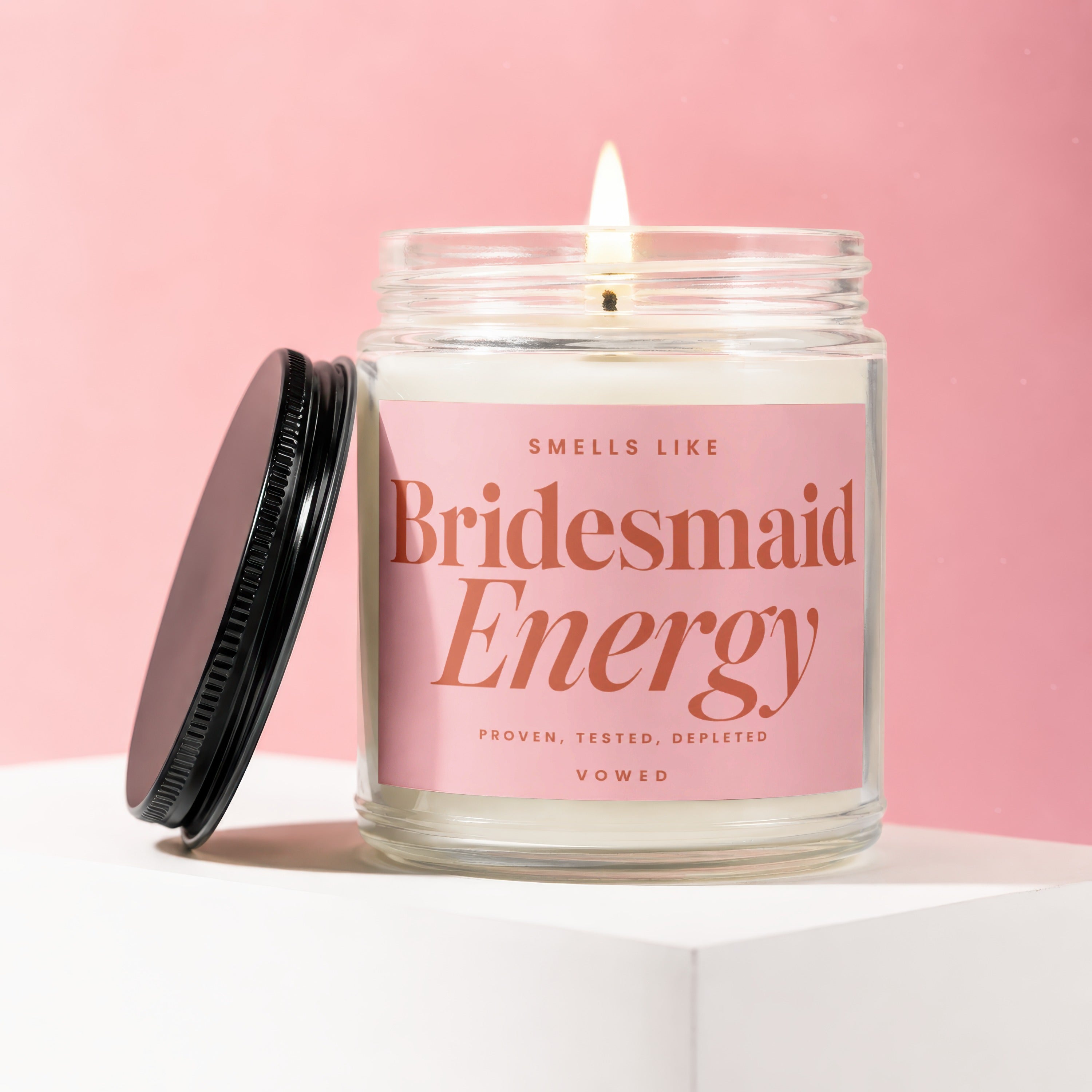 Glass candle with pink label reading "Smells Like Bridesmaid Energy"