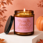 Amber candle with pink label reading "Proudly, finally, married VOWED."