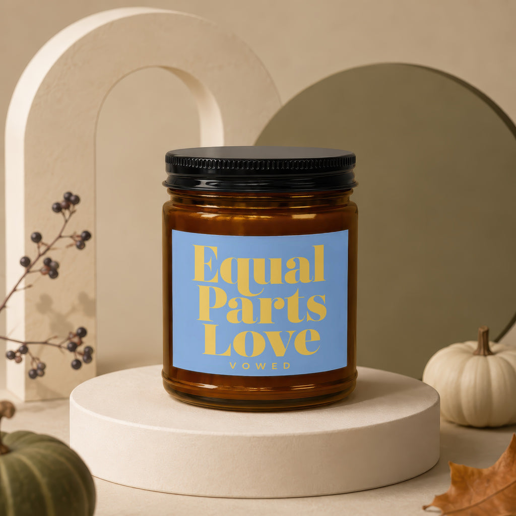 Amber glass candle with blue label reading "Equal Parts Love" and "vowed".