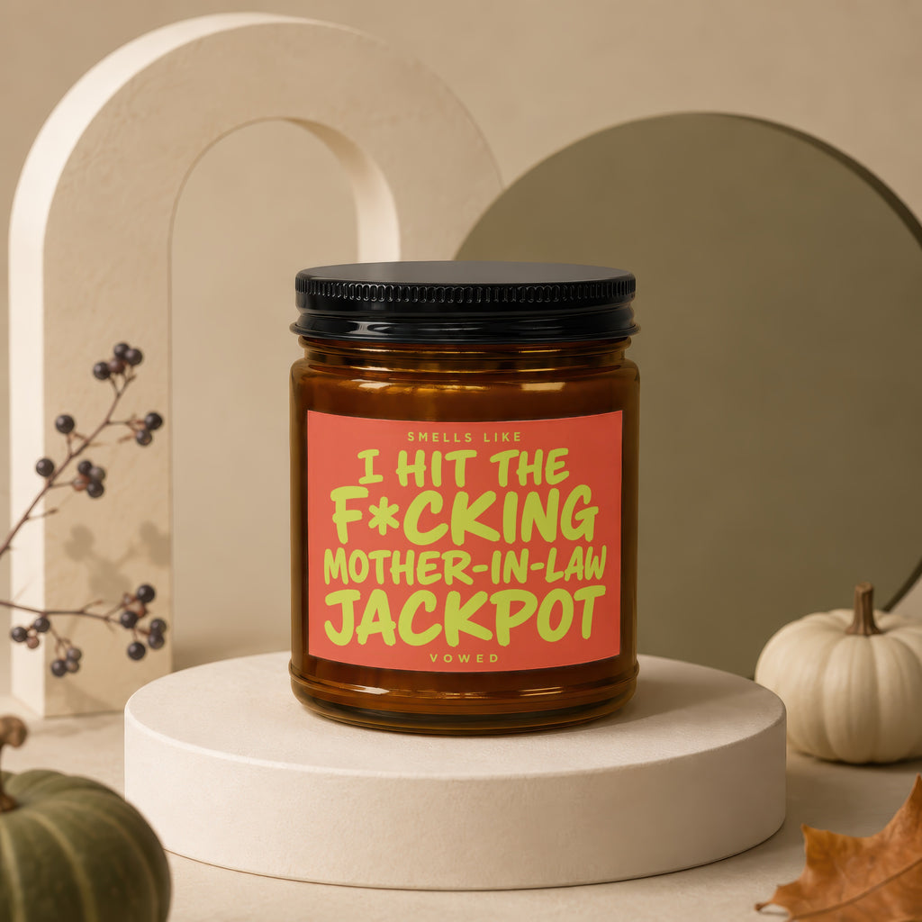 Candle with orange label reading "Smells like I hit the f*cking mother-in-law jackpot".