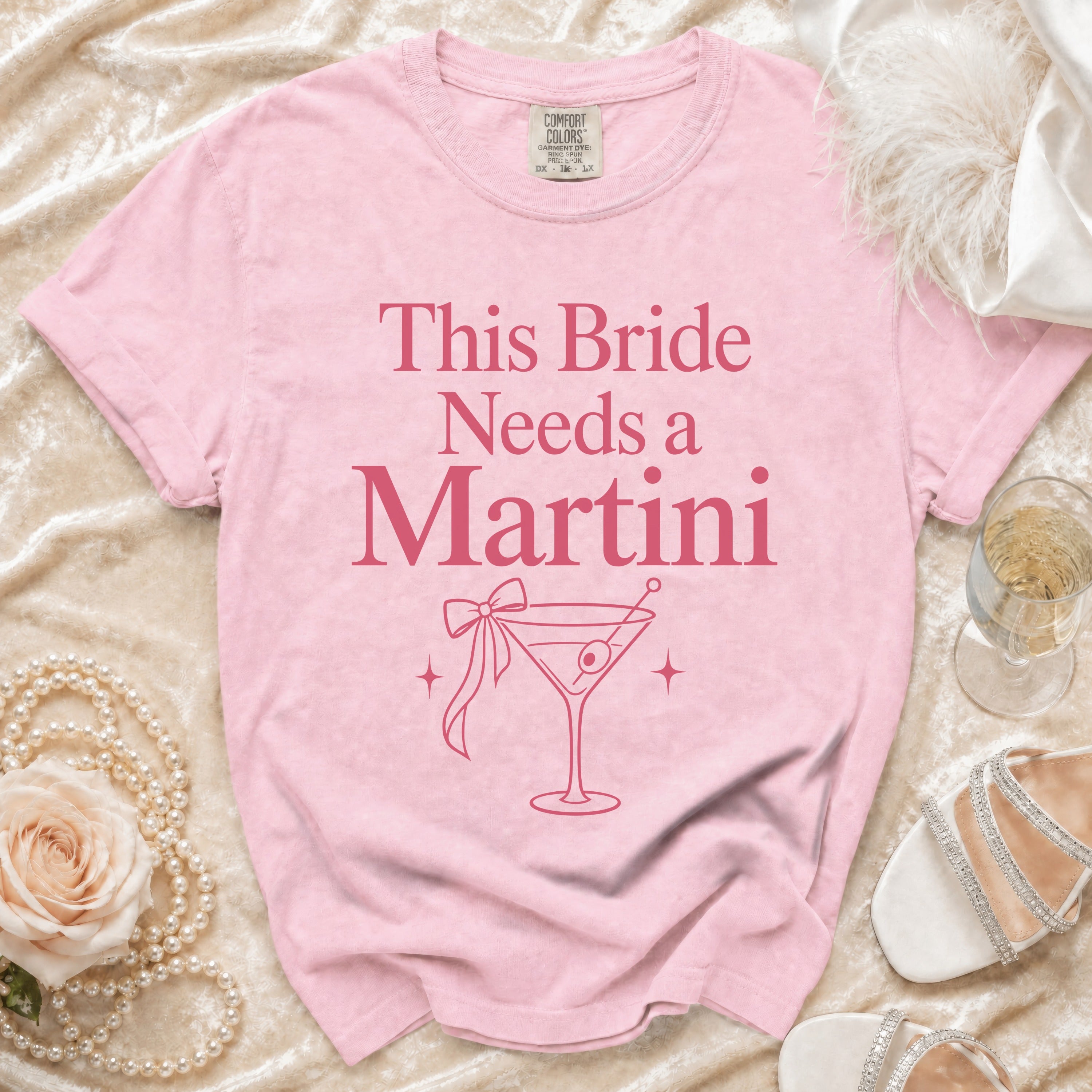 Pink t-shirt with "This Bride Needs a Martini" text and martini glass graphic.