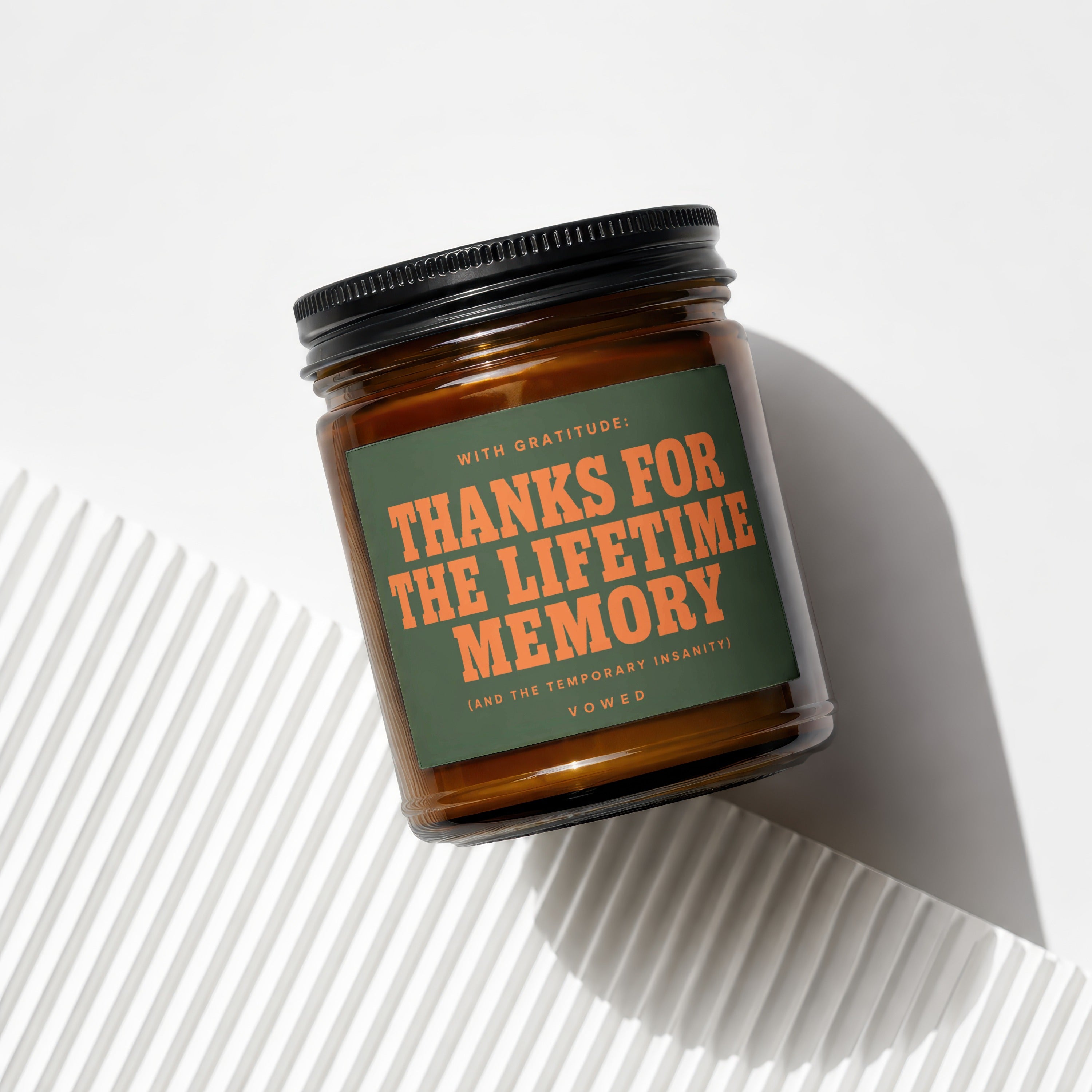 Amber jar candle with green label reading "Thanks for the lifetime memory" from Vowed.