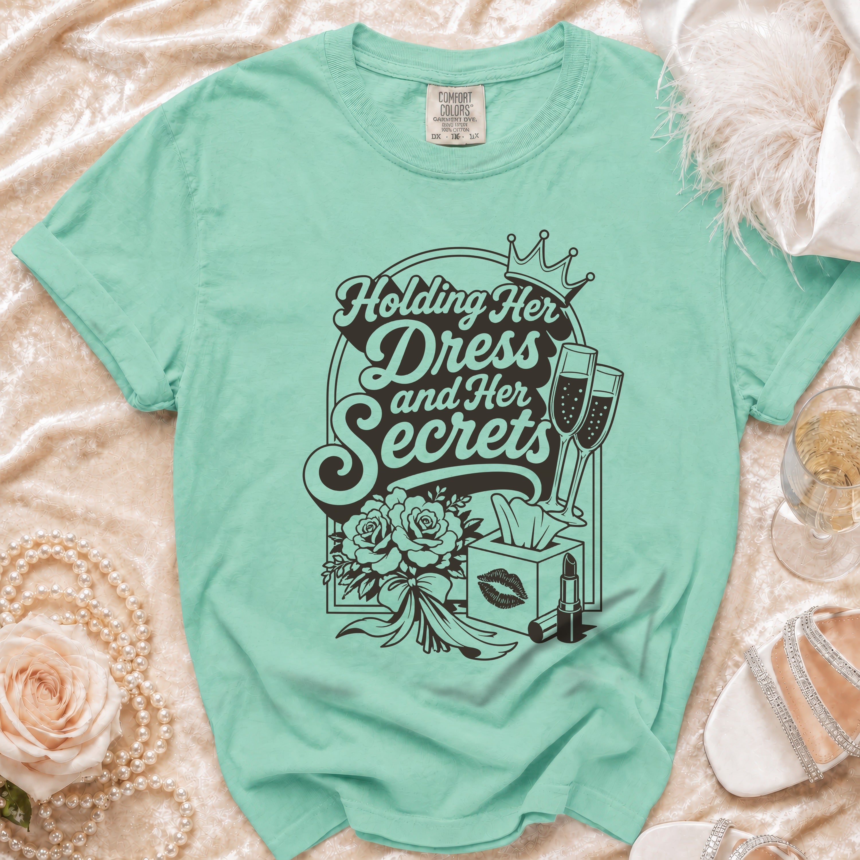 Mint green t-shirt with "Holding Her Dress and Her Secrets" graphic.