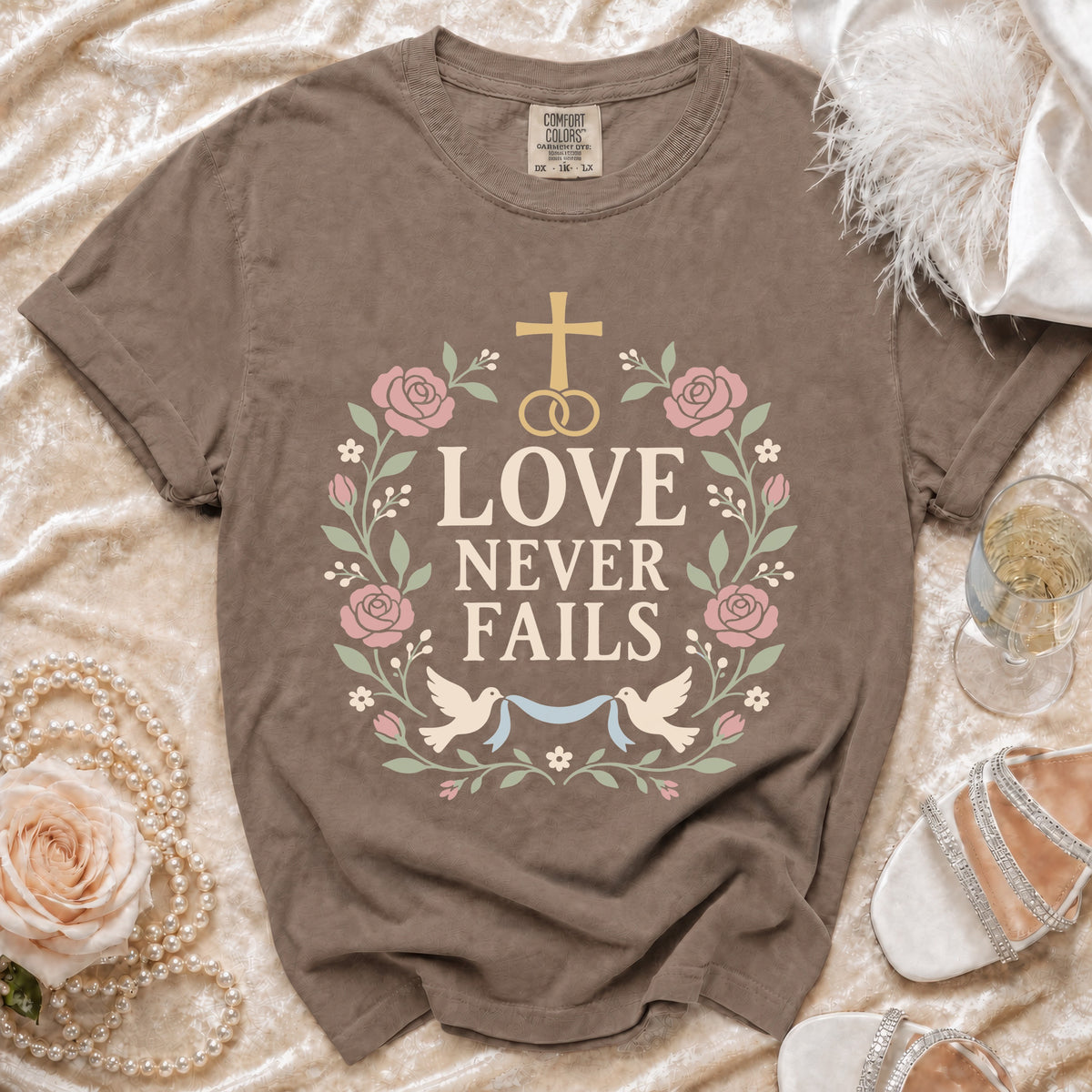 Brown t-shirt with "Love Never Fails" text and floral design.