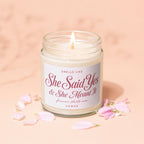 Burning candle in glass jar with "She Said Yes & She Meant It" label.