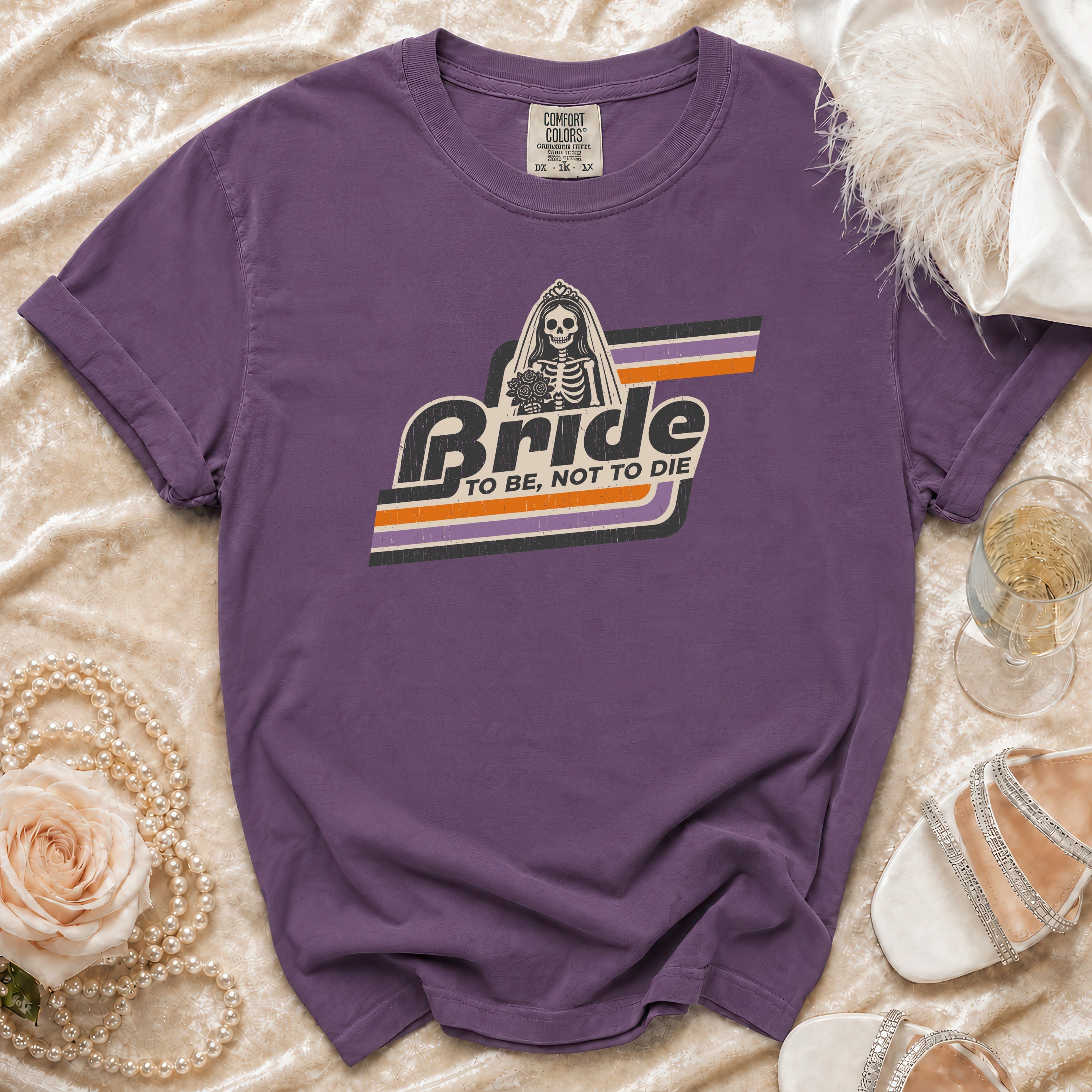 Purple t-shirt with skeleton bride graphic that says "Bride To Be, Not To Die".