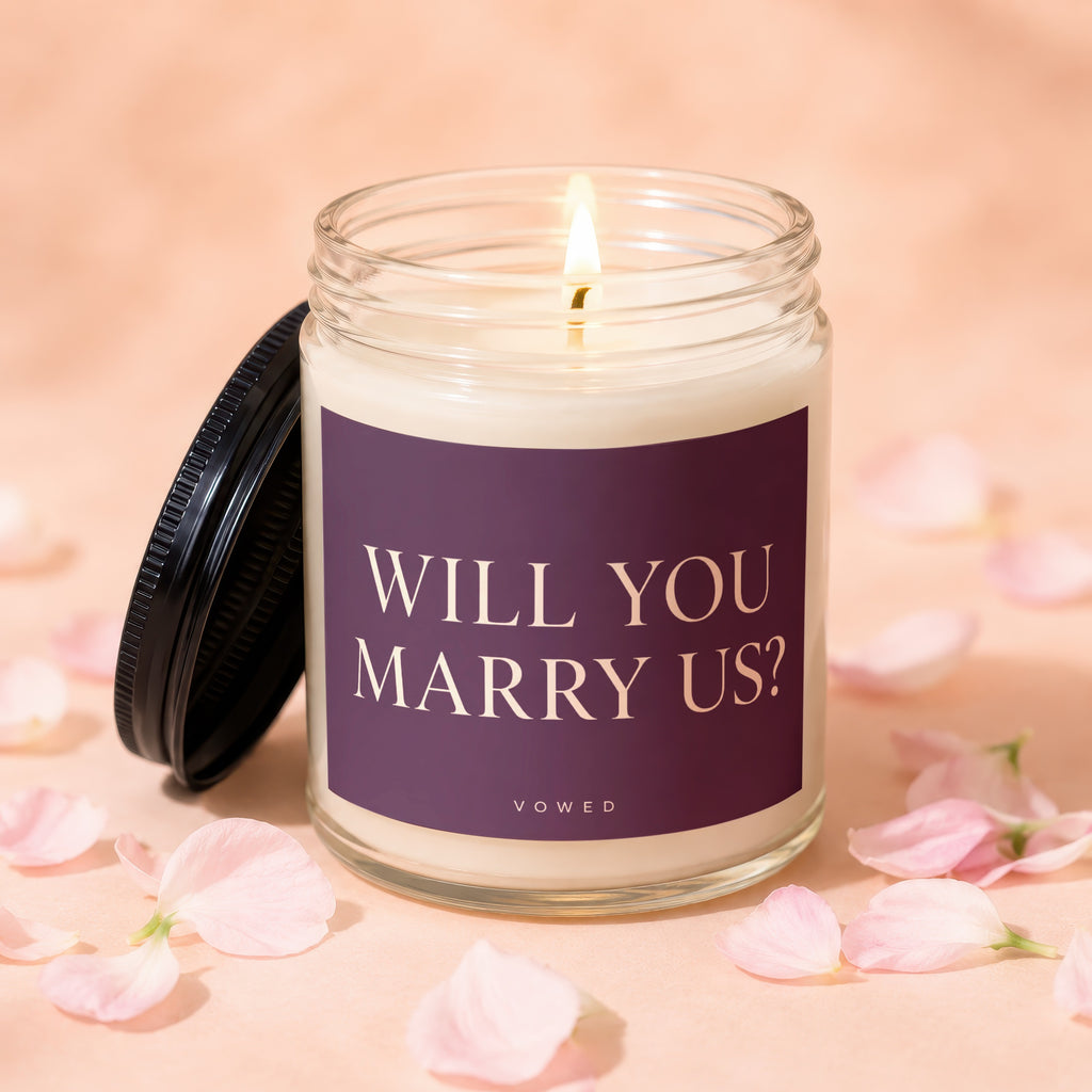 Scented candle with "WILL YOU MARRY US?" printed on its label.