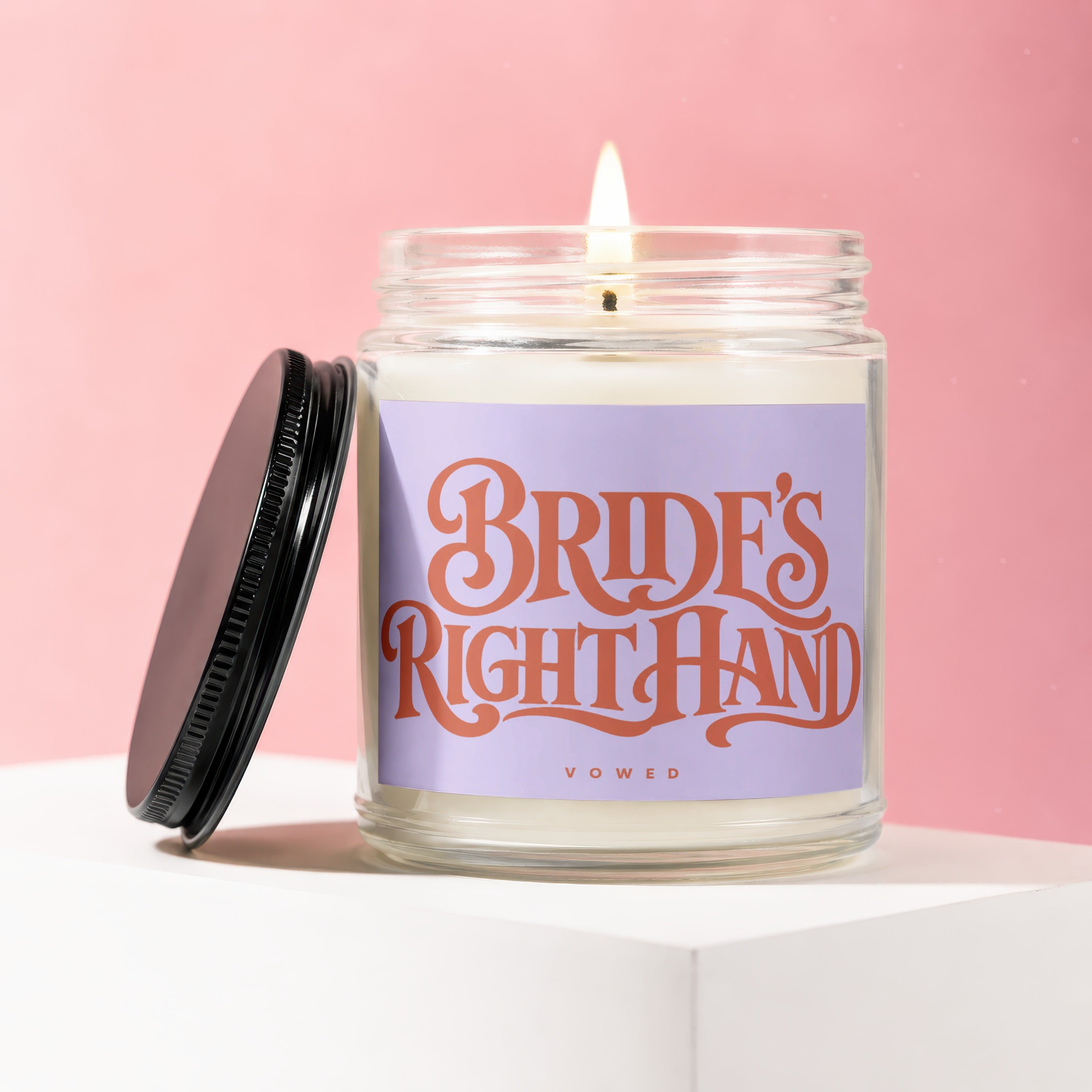 Jar candle with a lit wick and "Bride's Right Hand Vowed" text on a lavender label.