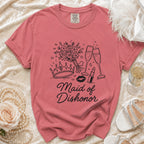 Pink t-shirt with "Maid of Dishonor" text and crown, flowers, lipstick, and kiss graphics.