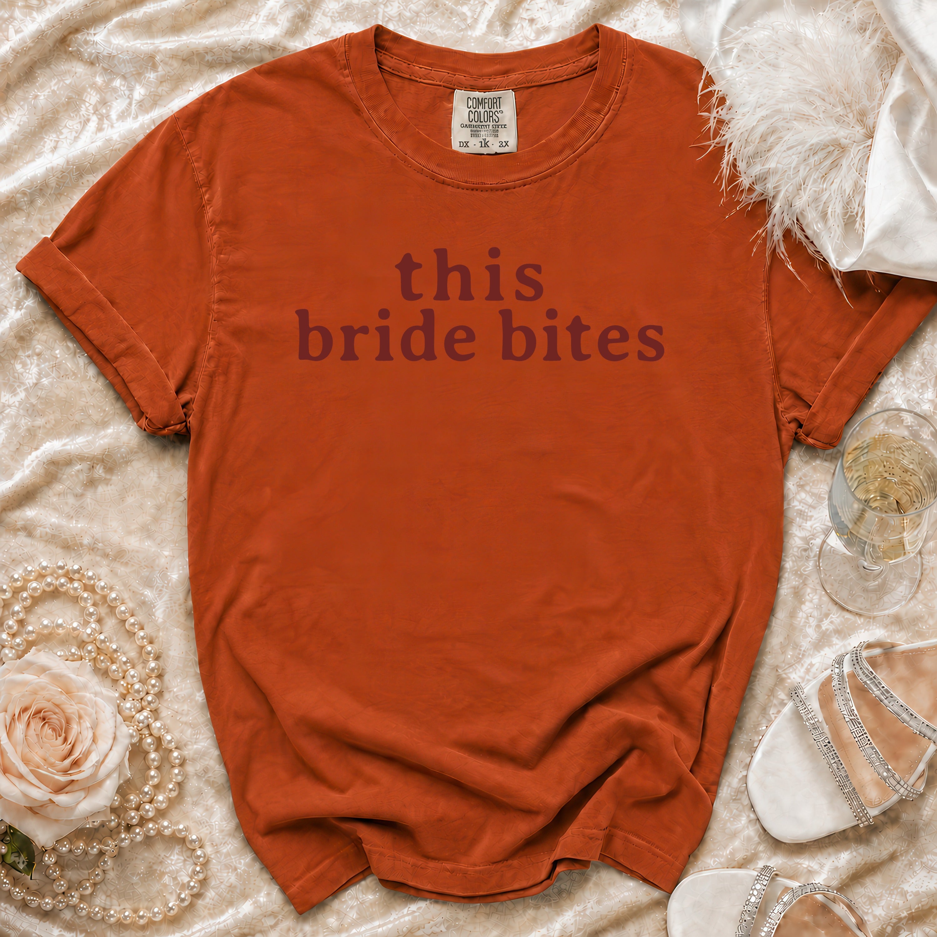 Comfort Colors t-shirt with "this bride bites" text, styled with pearls and heels.