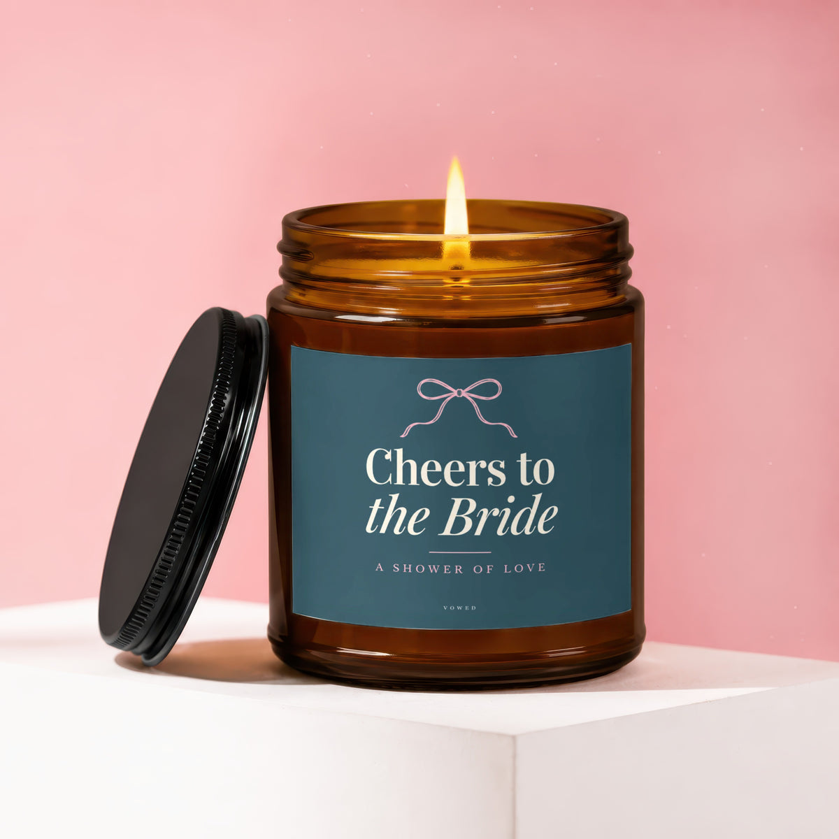 Lit candle in amber jar with label that reads "Cheers to the Bride".